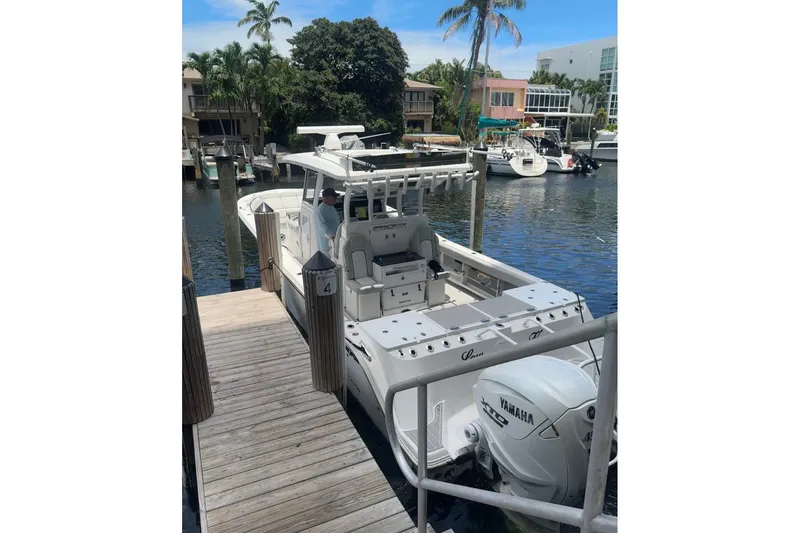Slide: The Image of 2023 Sea Fox 368 Commander docked, featuring Yamaha engines, surrounded by waterfront homes and palm trees. - 2