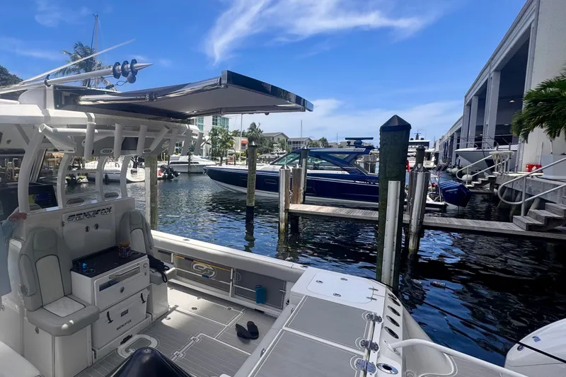 Slide: The Image of 2023 Sea Fox 368 Commander docked at a marina under a clear blue sky. - 46