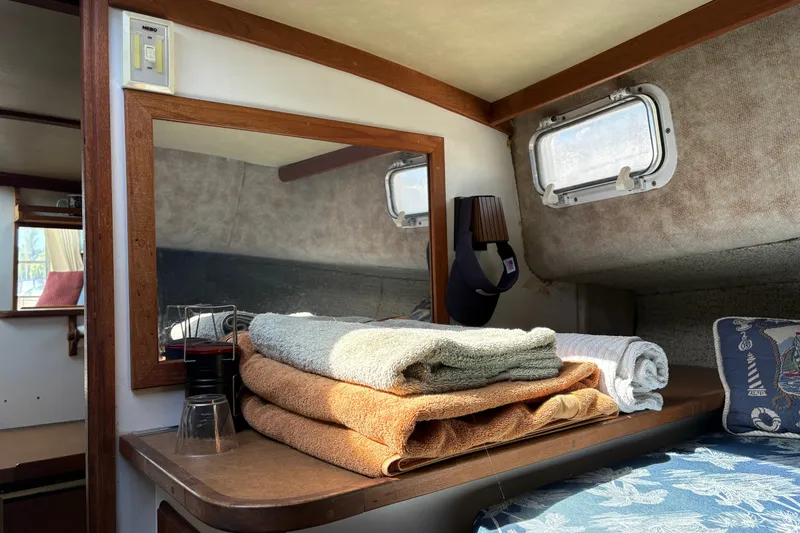 Slide: The Image of Interior of 1978 Mainship 34 Trawler with folded towels and nautical decor. - 29