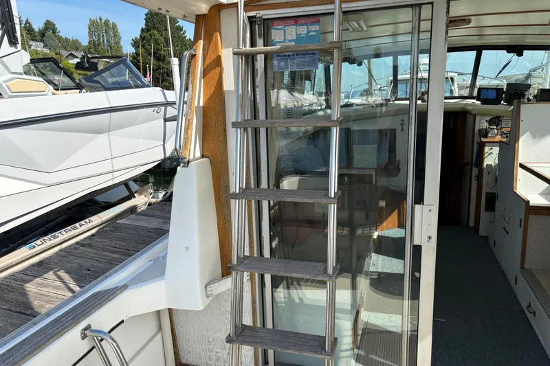 Slide: The Image of 1978 Mainship 34 Trawler interior with ladder and docked boats in background. - 10