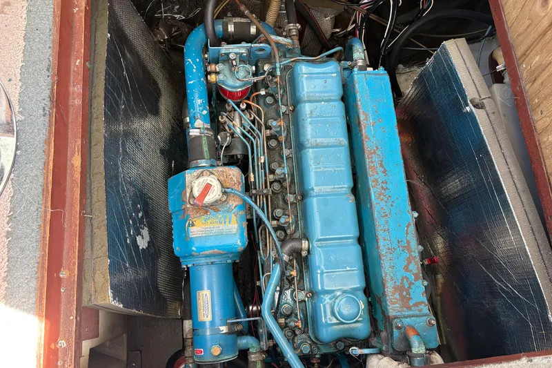 Slide: The Image of Engine compartment of a 1978 Mainship 34 Trawler, featuring a blue marine engine. - 33