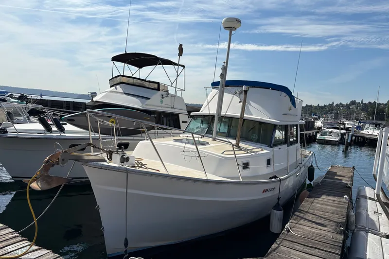 Slide: The Image of 1978 Mainship 34 Trawler docked at a marina under a clear sky. - 1