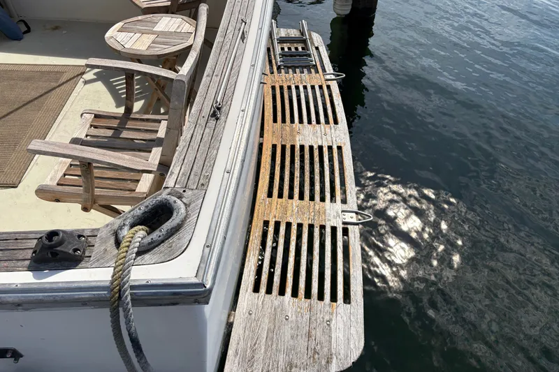 Slide: The Image of 1978 Mainship 34 Trawler deck with wooden chairs and water reflection. - 6