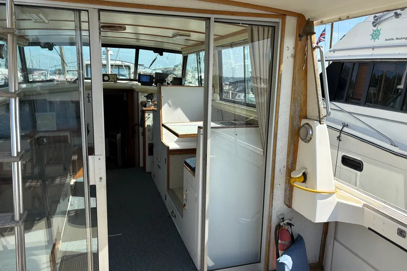Slide: The Image of 1978 Mainship 34 Trawler interior with helm, seating, and nautical equipment. - 11