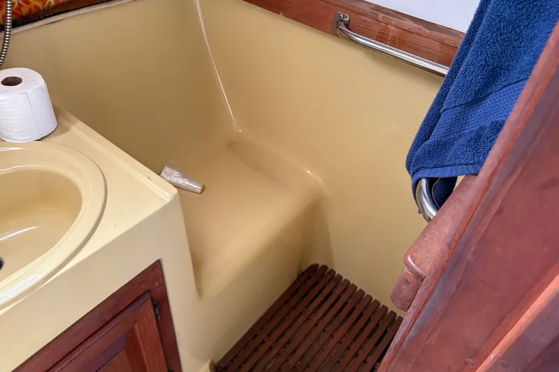 Slide: The Image of 1978 Mainship 34 Trawler bathroom with sink, towel, and toilet paper. - 32