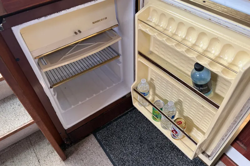 Slide: The Image of Open refrigerator on 1978 Mainship 34 Trawler, stocked with drinks and water bottles. - 27