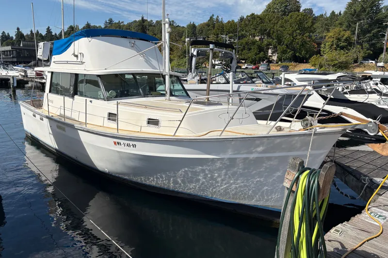 The Image of 1978 Mainship 34 Trawler docked at a marina, surrounded by other boats. - 0