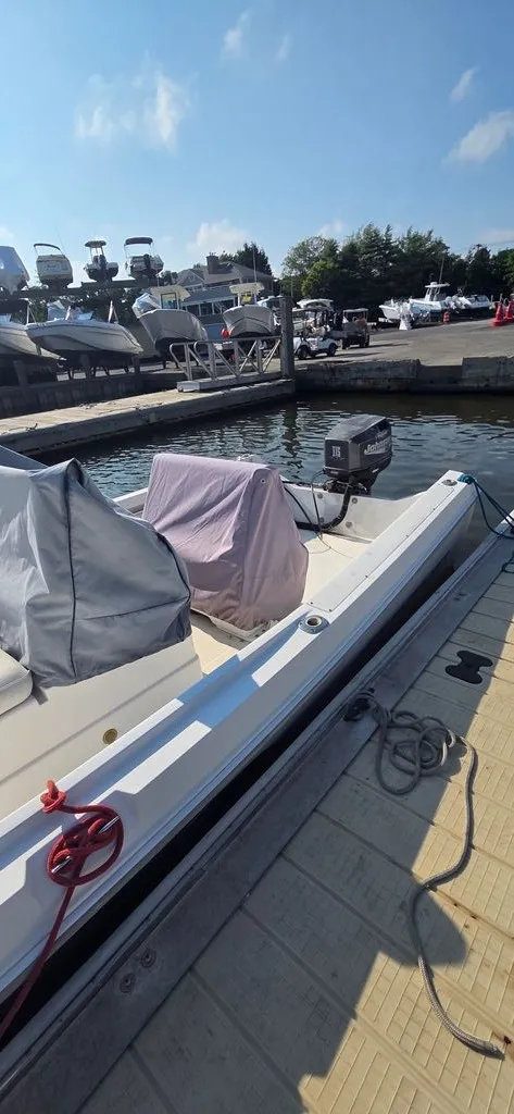 Slide: The Image of A 1999 Aquasport 200 Osprey is docked. Other boats are visible in the background. - 5