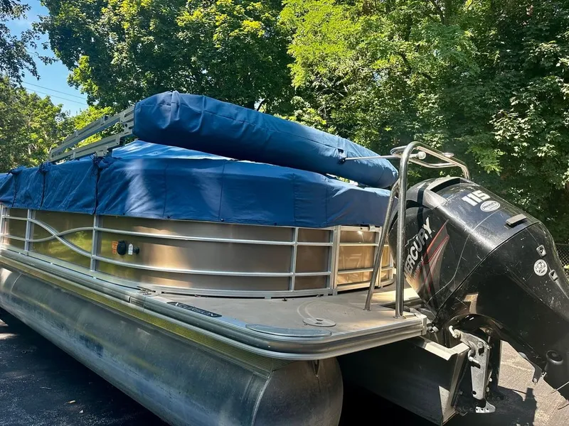 Slide: The Image of A 2013 Xcursion 23RF pontoon boat with a blue cover and a Mercury outboard motor. - 19