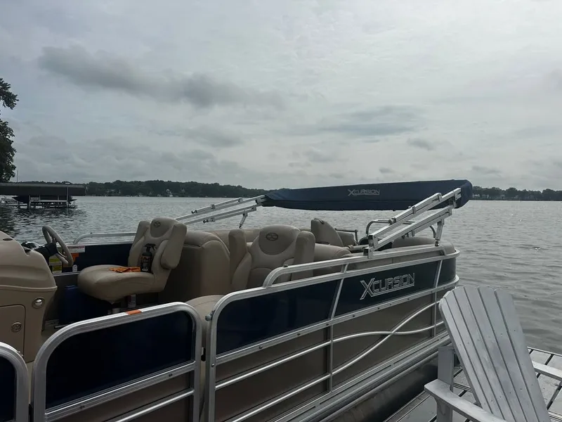 Slide: The Image of A 2013 Xcursion 23RF pontoon boat docked by a calm lake under a gray sky. - 17