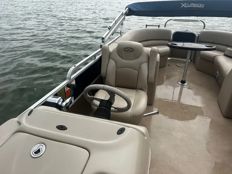 Slide: The Image of The image shows a pontoon boat on the water with beige leather seats and a helm station. - 5