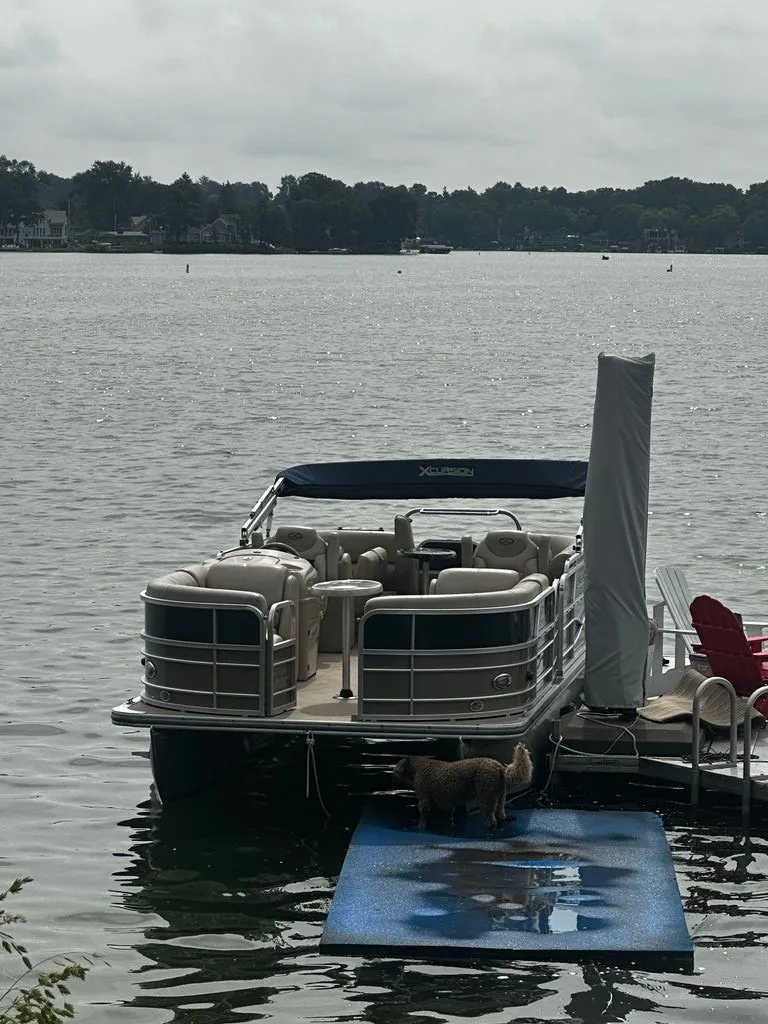 Slide: The Image of A 2013 Xcursion 23RF pontoon boat is docked. A dog stands on a blue mat. - 10