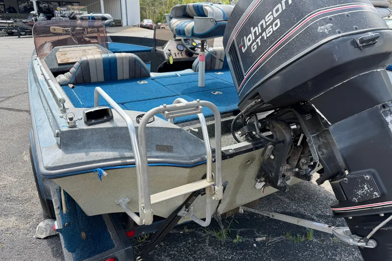 Slide: The Image of 1989 Ranger 373V boat with Johnson GT150 outboard motor, blue interior, and trailer. - 2