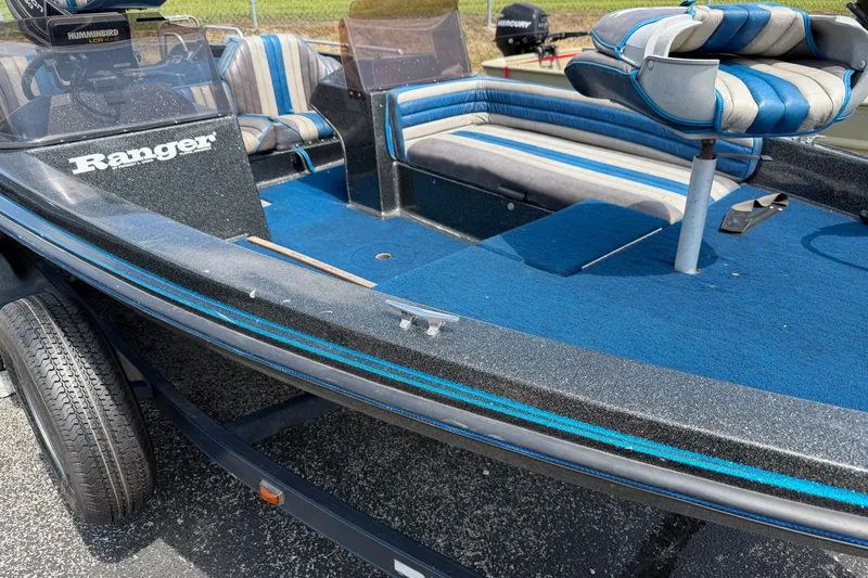 Slide: The Image of 1989 Ranger 373V boat interior with blue and gray seating, on a trailer. - 5