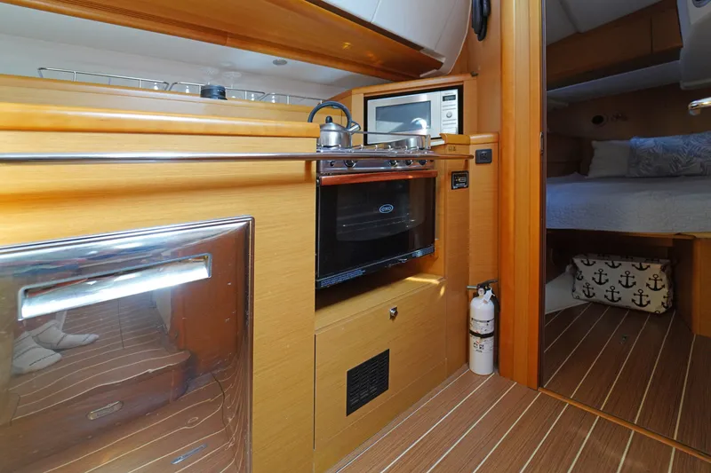 Slide: The Image of Interior of 2011 Jeanneau Sun Odyssey 50 DS yacht, featuring a modern kitchen and cozy bedroom. - 26