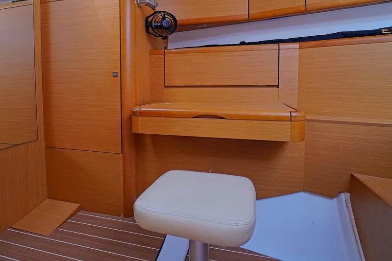 Slide: The Image of Interior of 2011 Jeanneau Sun Odyssey 50 DS yacht with wooden cabinetry and cushioned stool. - 29