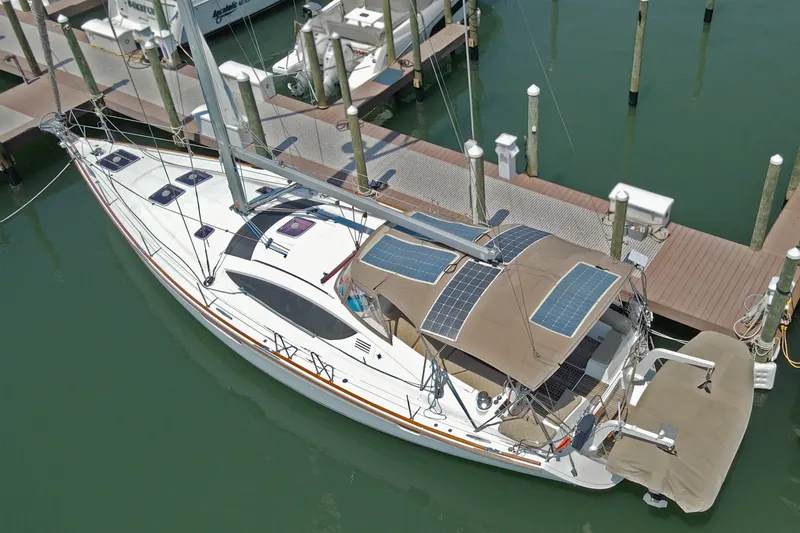 Slide: The Image of 2011 Jeanneau Sun Odyssey 50 DS sailboat docked, featuring solar panels and sleek design. - 3