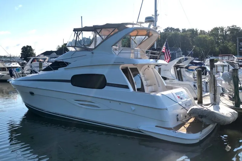 Slide: The Image of 2004 Silverton 410 Sport Bridge yacht docked at marina, featuring sleek design and spacious deck. - 3
