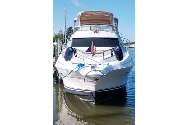 Slide: The Image of 2004 Silverton 410 Sport Bridge yacht docked in a marina, front view. - 4