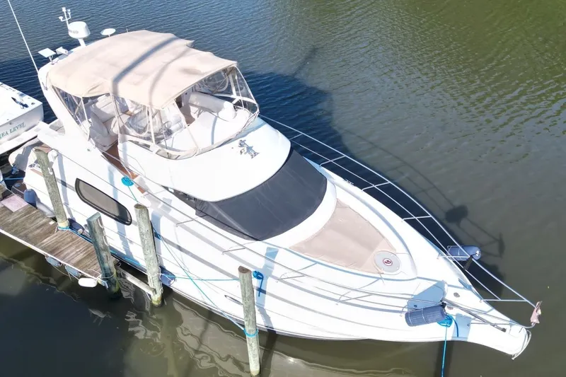 Slide: The Image of 2004 Silverton 410 Sport Bridge yacht docked on calm water, aerial view. - 1