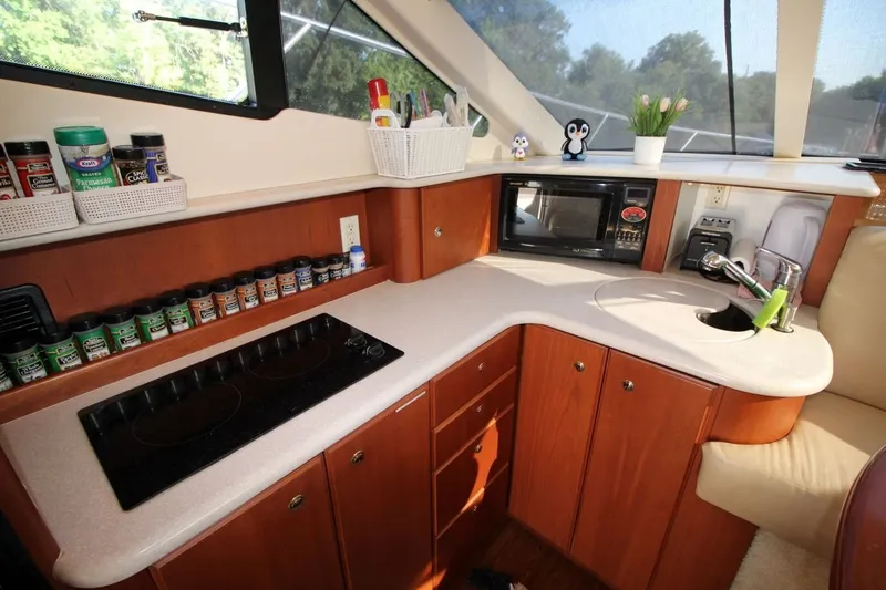Slide: The Image of 2004 Silverton 410 Sport Bridge yacht kitchen with stove, microwave, and spice rack. - 26