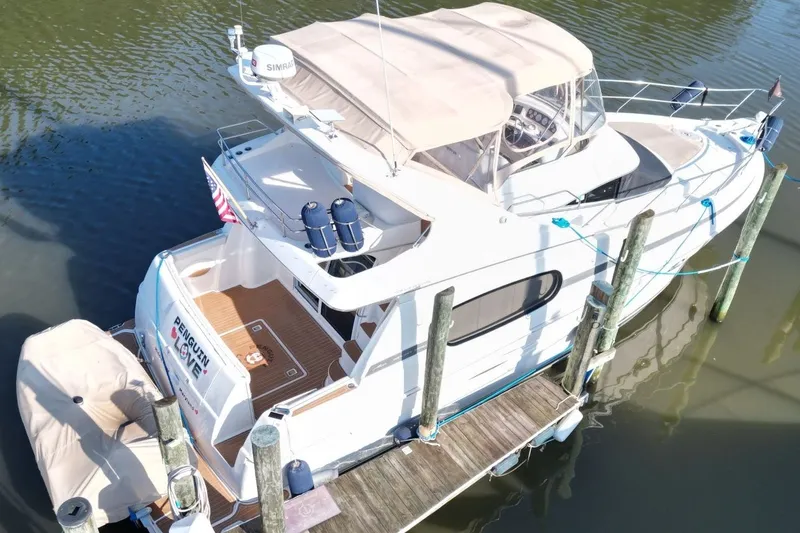 Slide: The Image of 2004 Silverton 410 Sport Bridge yacht docked, featuring spacious deck and elegant design. - 5