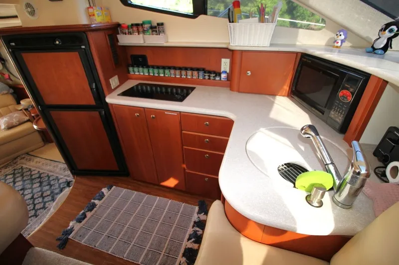 Slide: The Image of 2004 Silverton 410 Sport Bridge yacht kitchen with sink, stove, and microwave. - 27