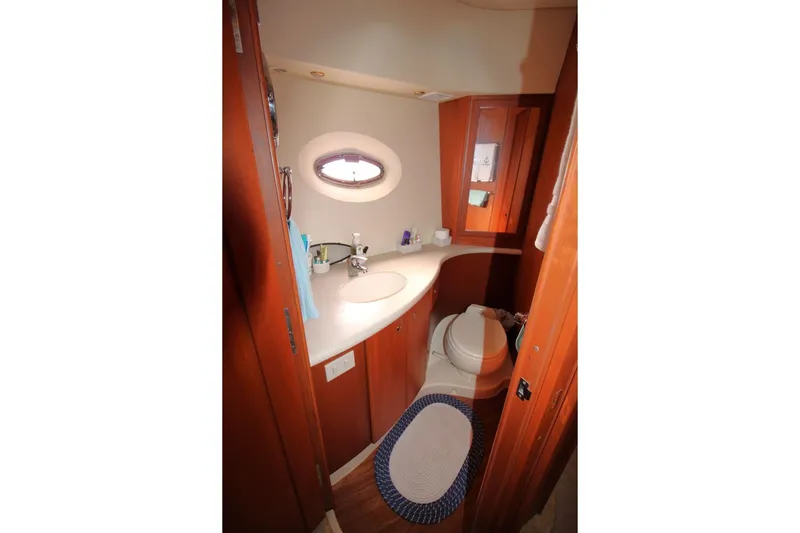 Slide: The Image of 2004 Silverton 410 Sport Bridge bathroom with wooden cabinetry and oval window. - 31