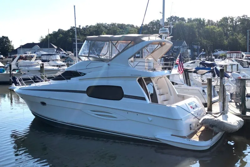 Slide: The Image of 2004 Silverton 410 Sport Bridge yacht docked at a marina, surrounded by other boats. - 9