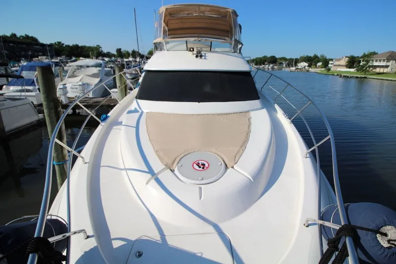Slide: The Image of 2004 Silverton 410 Sport Bridge yacht docked in a marina, showcasing sleek design and spacious deck. - 10