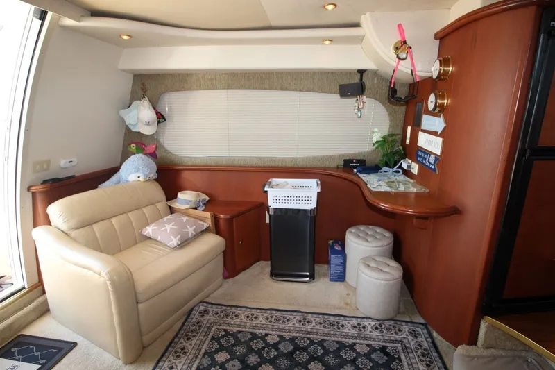 Slide: The Image of Interior of 2004 Silverton 410 Sport Bridge with beige seating and wooden cabinetry. - 23