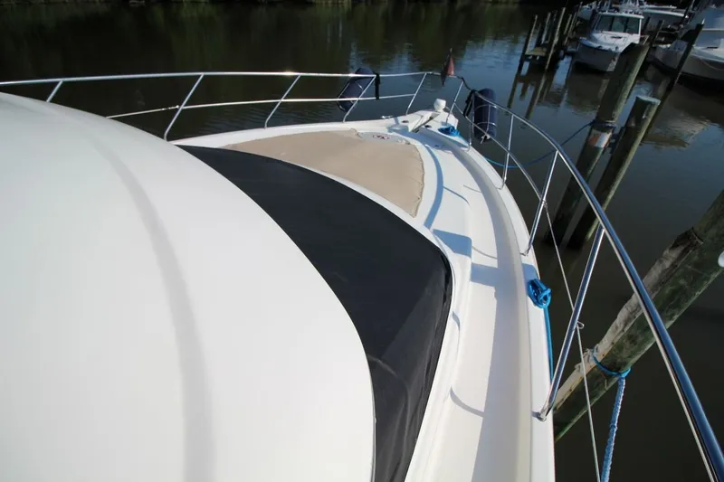 Slide: The Image of 2004 Silverton 410 Sport Bridge yacht docked at marina, showcasing sleek deck design. - 11