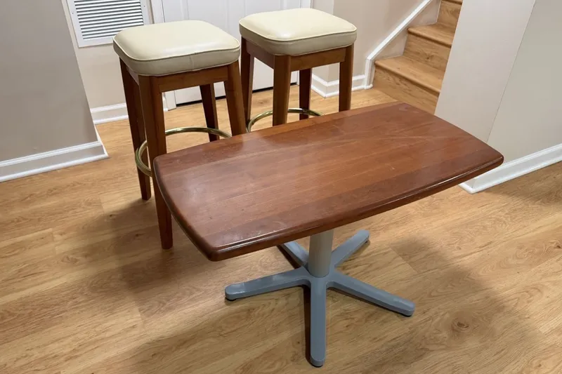 Slide: The Image of Wooden table and two stools on a light wood floor, near stairs. - 37