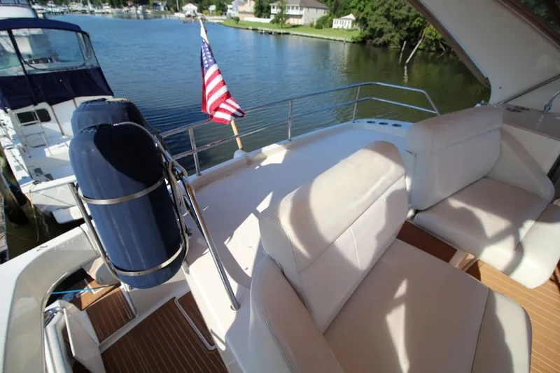 Slide: The Image of 2004 Silverton 410 Sport Bridge yacht deck with seating and American flag. - 18