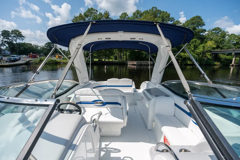 Slide: The Image of 2008 Formula 310 Bowrider boat interior with blue canopy on a calm river. - 18