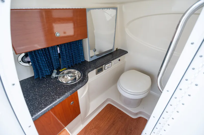 Slide: The Image of 2008 Formula 310 Bowrider boat bathroom with sink, toilet, and wooden cabinetry. - 22