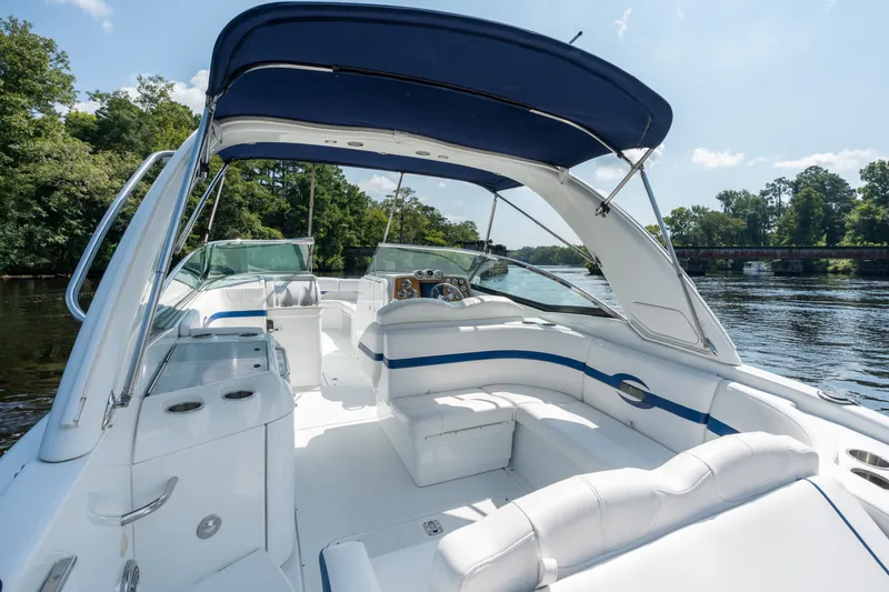 Slide: The Image of 2008 Formula 310 Bowrider boat with spacious seating and canopy on a scenic river. - 40