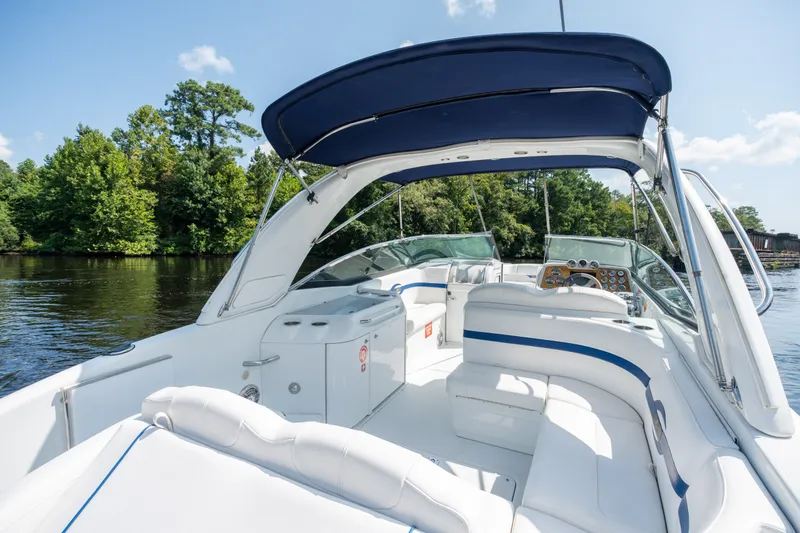Slide: The Image of 2008 Formula 310 Bowrider boat interior with blue canopy on a serene lake. - 38