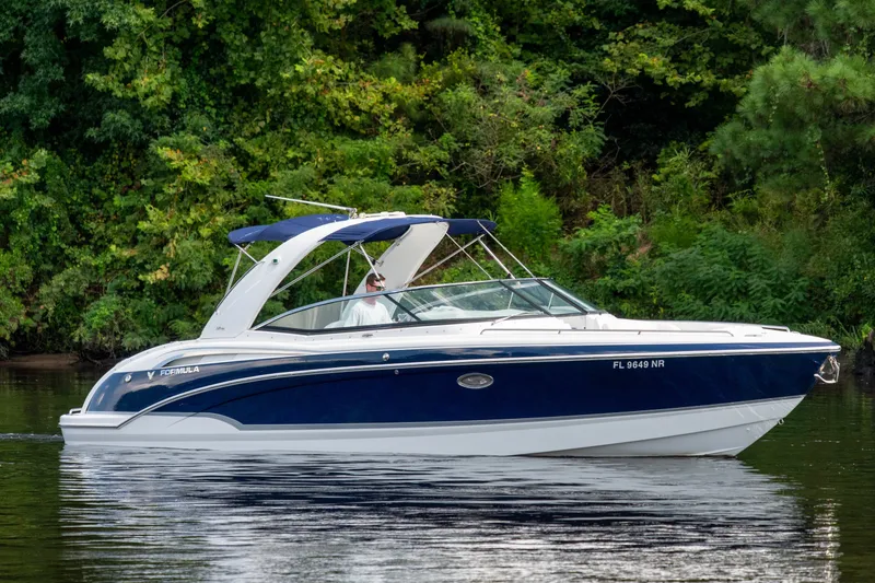 The Image of 2008 Formula 310 Bowrider boat cruising on a calm lake with lush greenery. - 0