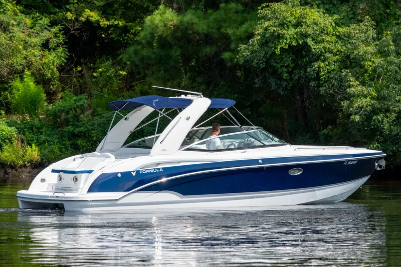 Slide: The Image of 2008 Formula 310 Bowrider cruising on a calm lake surrounded by lush greenery. - 4