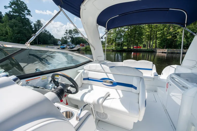 Slide: The Image of 2008 Formula 310 Bowrider interior with white seating, steering wheel, and canopy on a calm lake. - 19