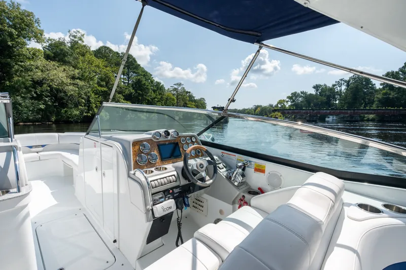 Slide: The Image of 2008 Formula 310 Bowrider boat interior with steering wheel, dashboard, and seating on a scenic river. - 27