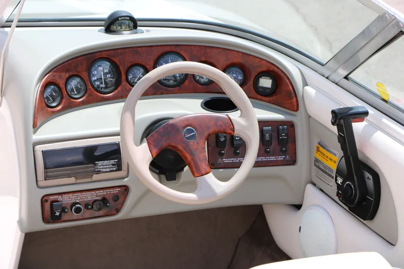 Slide: The Image of Dashboard of a 1997 Chaparral 2130 SS boat with wood accents and steering wheel. - 21