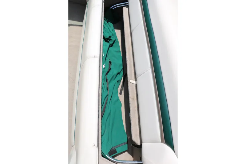 Slide: The Image of Storage compartment in a 1997 Chaparral 2130 SS boat with green cover inside. - 44