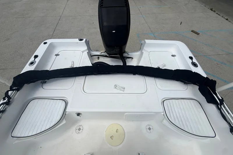 Slide: The Image of 2004 Sea Fox 225 Bay Fisher boat deck with motor, featuring storage compartments. - 13