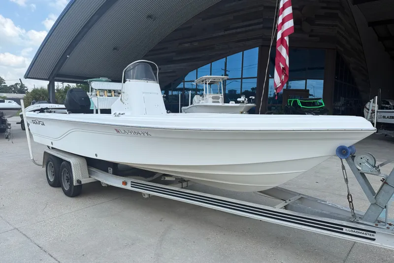 Slide: The Image of 2004 Sea Fox 225 Bay Fisher boat on trailer, displayed outdoors with American flag. - 3