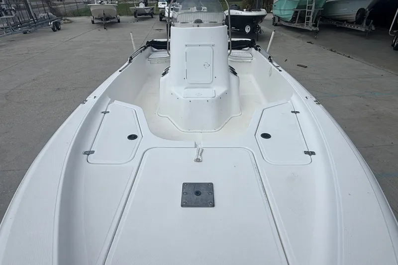 Slide: The Image of 2004 Sea Fox 225 Bay Fisher boat deck, spacious layout, white finish, parked outdoors. - 11