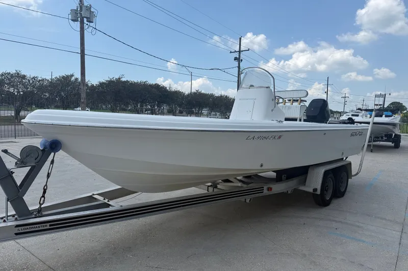 Slide: The Image of 2004 Sea Fox 225 Bay Fisher boat on trailer under a clear blue sky. - 4