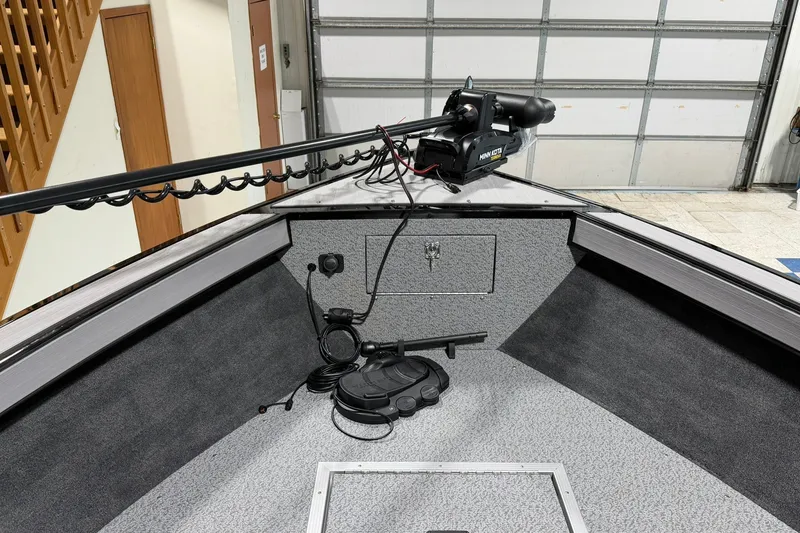Slide: The Image of 2027 Starcraft Fishmaster 210 boat interior with trolling motor in a garage setting. - 7