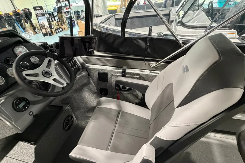 Slide: The Image of Interior of 2027 Starcraft Fishmaster 210 boat with steering wheel and captain's chair. - 14